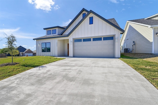 modern farmhouse featuring cooling unit, a front lawn, and a garage