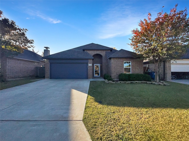 view of front of property featuring a front yard and a garage