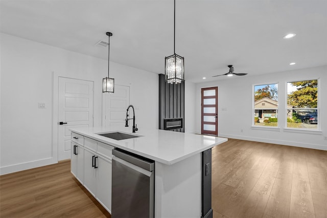 kitchen with hardwood / wood-style floors, dishwasher, a kitchen island with sink, white cabinets, and sink