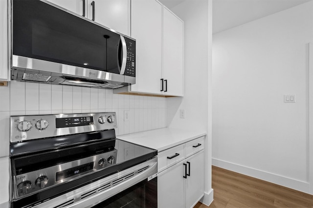 kitchen featuring decorative backsplash, white cabinetry, light hardwood / wood-style flooring, and appliances with stainless steel finishes