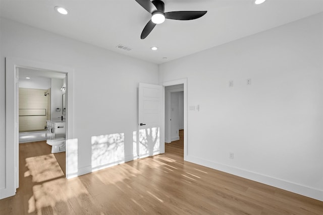 unfurnished bedroom featuring ensuite bath, ceiling fan, and light hardwood / wood-style flooring