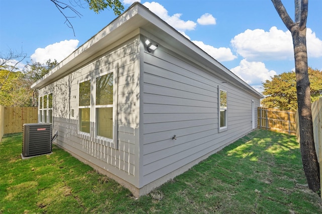 view of side of home featuring a lawn and central air condition unit