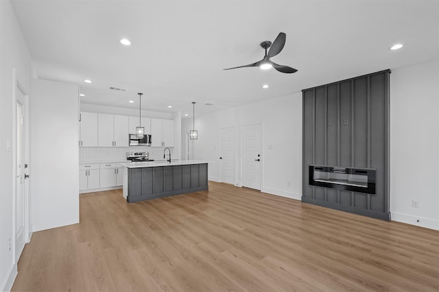 interior space with ceiling fan, light wood-type flooring, sink, and heating unit