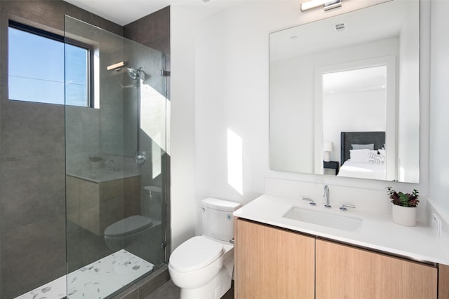 bathroom featuring toilet, tiled shower, and vanity