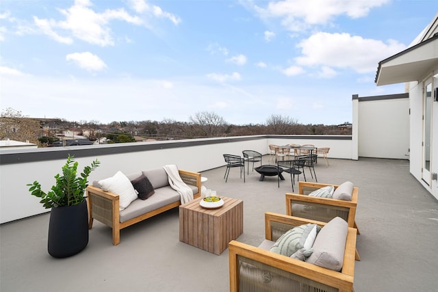 view of patio with a balcony and an outdoor living space with a fire pit