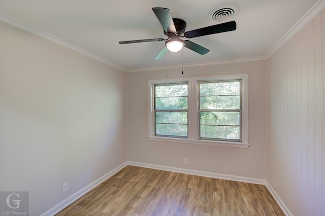 empty room featuring crown molding, ceiling fan, wood-type flooring, and wood walls