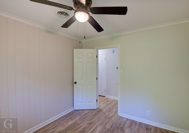 unfurnished room with ceiling fan, light hardwood / wood-style flooring, and ornamental molding