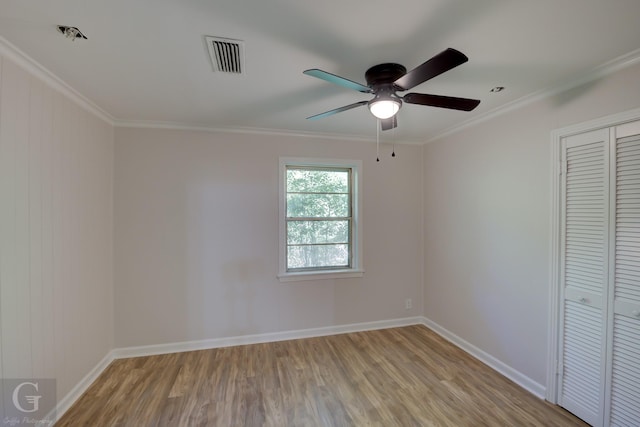 unfurnished bedroom with ceiling fan, light hardwood / wood-style floors, ornamental molding, and a closet