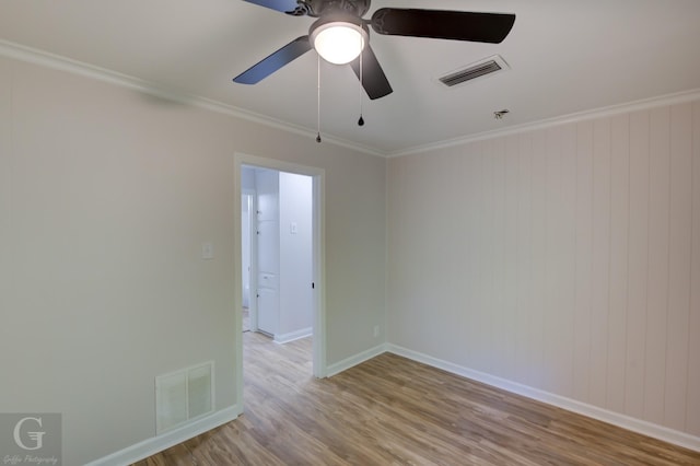 unfurnished room with wood walls, ceiling fan, light hardwood / wood-style floors, and ornamental molding