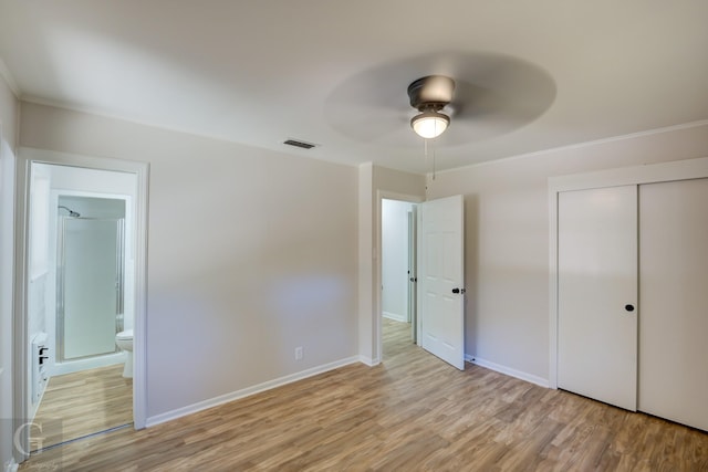 unfurnished bedroom featuring ceiling fan, connected bathroom, a closet, and light wood-type flooring