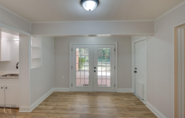 doorway to outside featuring sink, french doors, crown molding, and light wood-type flooring