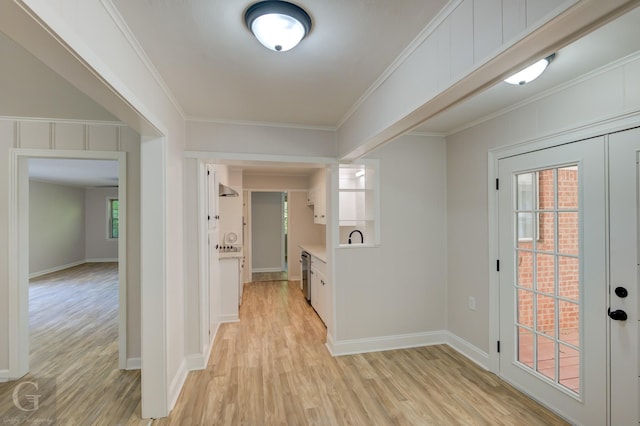 foyer entrance featuring crown molding and light hardwood / wood-style flooring