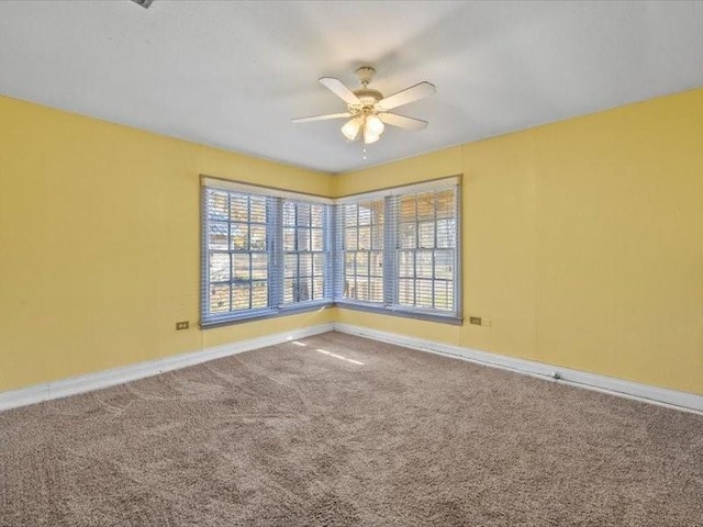 carpeted spare room featuring ceiling fan