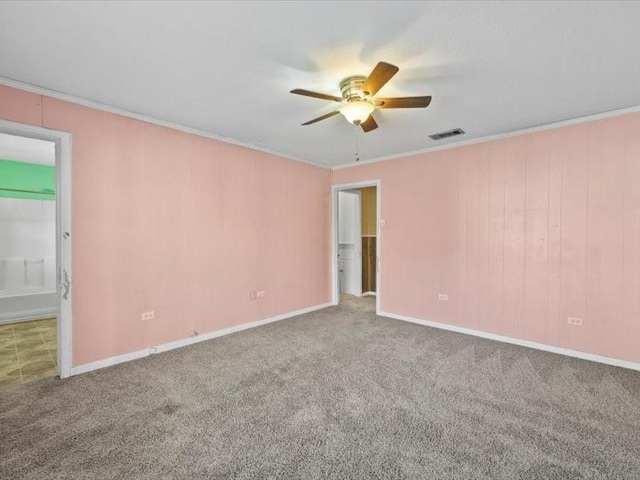 empty room with ceiling fan, carpet floors, and ornamental molding