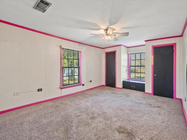 carpeted empty room featuring ornamental molding and ceiling fan