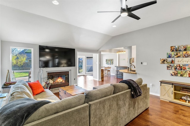 living room with wood-type flooring, ceiling fan, and lofted ceiling