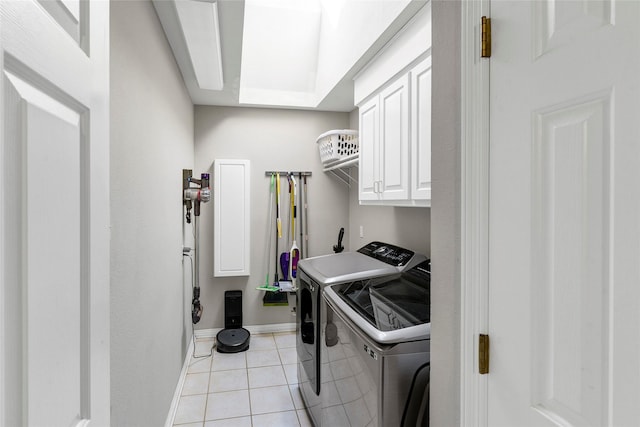 washroom featuring cabinets, washing machine and dryer, and light tile patterned floors