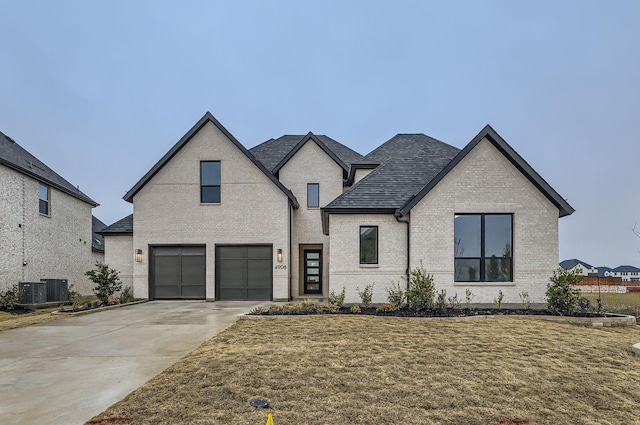 french country style house with a garage and a front yard