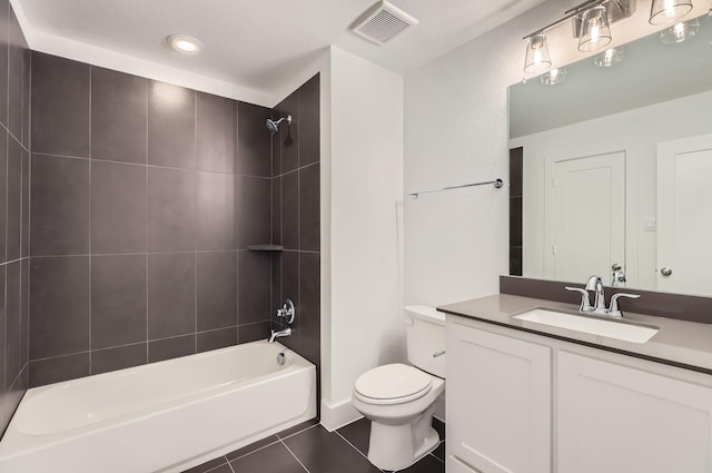 full bathroom with tile patterned floors, toilet, tiled shower / bath combo, and vanity