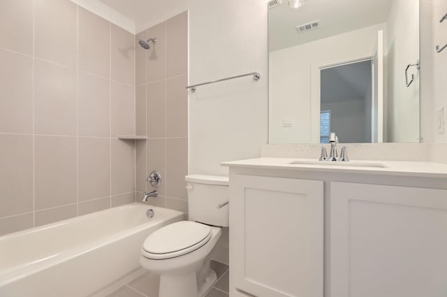 full bathroom featuring vanity, tiled shower / bath combo, tile patterned floors, and toilet