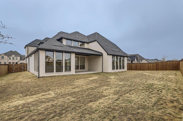 rear view of house with a yard and a patio area