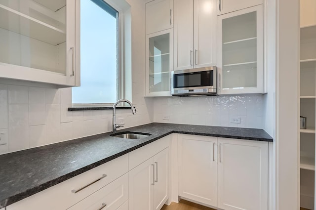 kitchen with sink, white cabinets, and backsplash