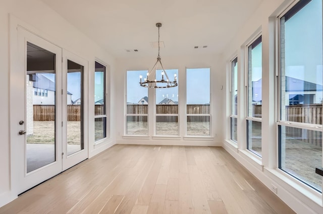 unfurnished sunroom with an inviting chandelier