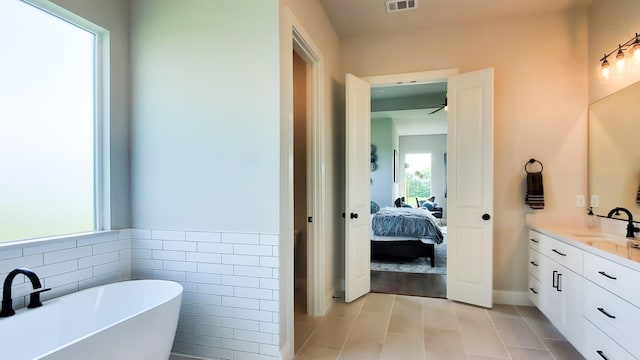 bathroom featuring vanity, tile walls, and a bathing tub