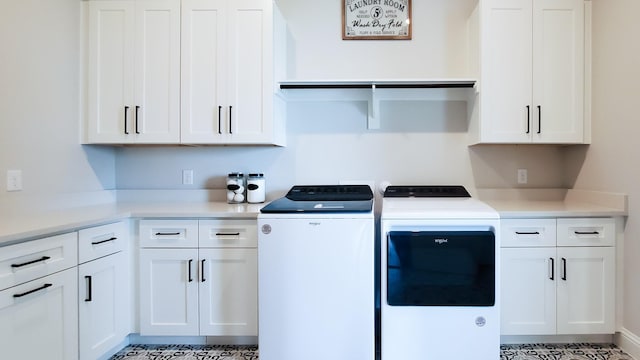 washroom with cabinets and washer and clothes dryer