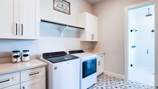 washroom featuring cabinets, washing machine and dryer, and light tile patterned floors