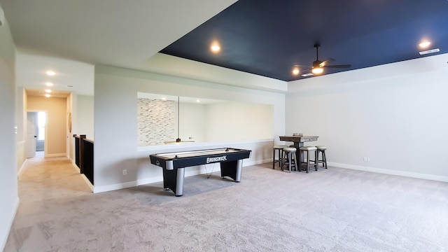 game room featuring ceiling fan, a raised ceiling, and light carpet