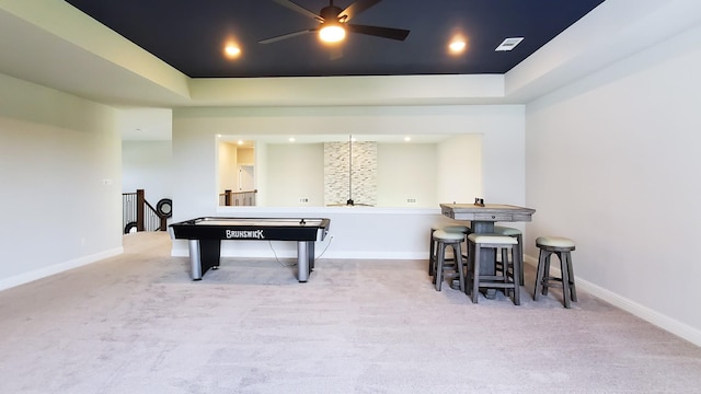 playroom featuring light carpet, a tray ceiling, and ceiling fan