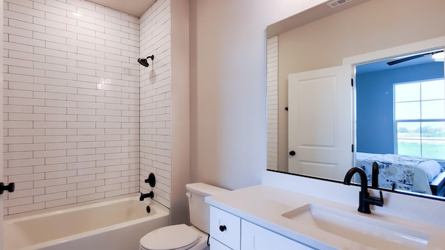 full bathroom with vanity, tiled shower / bath combo, and toilet