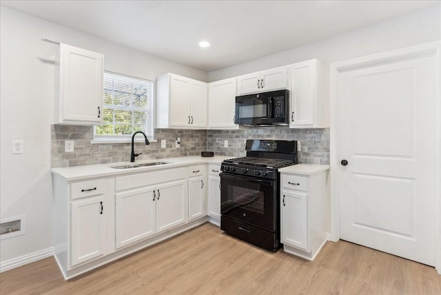 kitchen with white cabinetry, sink, black appliances, and light hardwood / wood-style floors