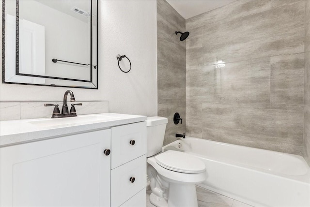 full bathroom with toilet, vanity, and tiled shower / bath