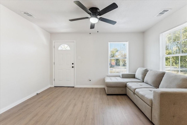 living room featuring light hardwood / wood-style flooring and ceiling fan