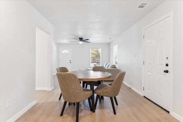 dining space with ceiling fan and light hardwood / wood-style flooring