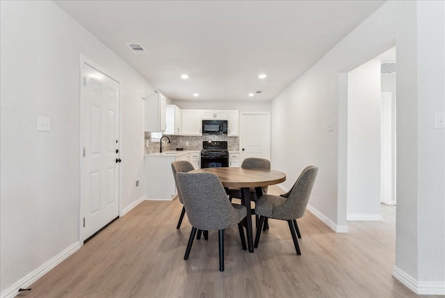 dining area with light hardwood / wood-style floors and sink