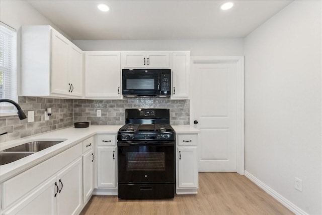 kitchen with black appliances, sink, light hardwood / wood-style flooring, decorative backsplash, and white cabinetry