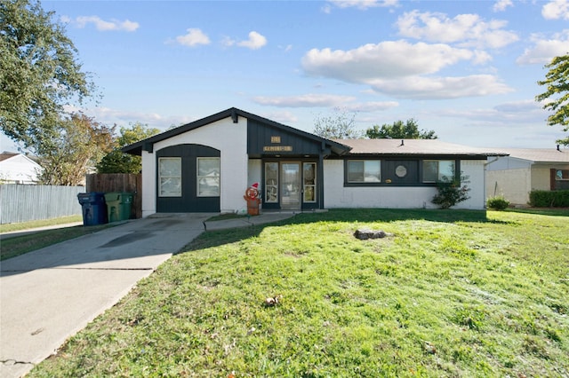 ranch-style house featuring a front yard and french doors