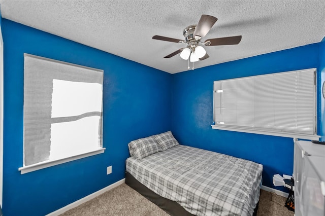 bedroom featuring carpet flooring, ceiling fan, and a textured ceiling