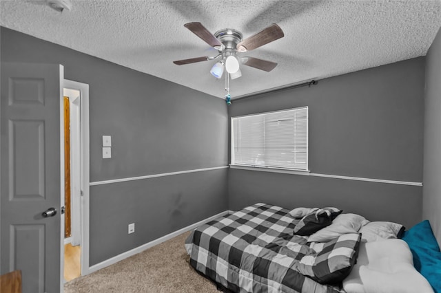 bedroom with a textured ceiling, light colored carpet, and ceiling fan