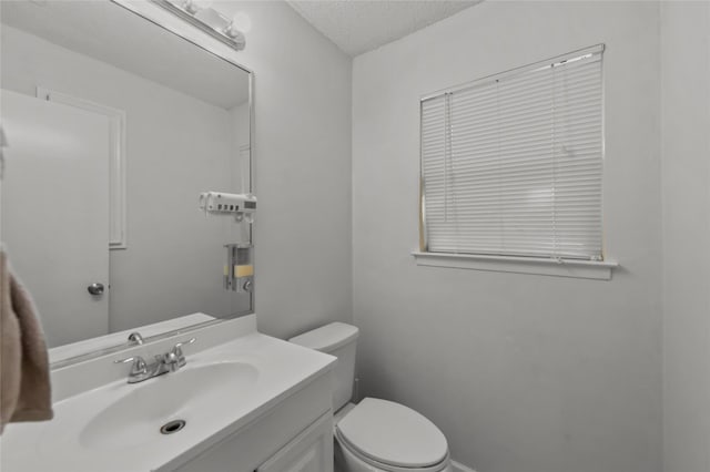 bathroom featuring vanity, toilet, and a textured ceiling