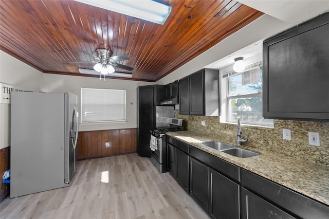 kitchen featuring sink, stainless steel gas range, tasteful backsplash, light hardwood / wood-style flooring, and fridge