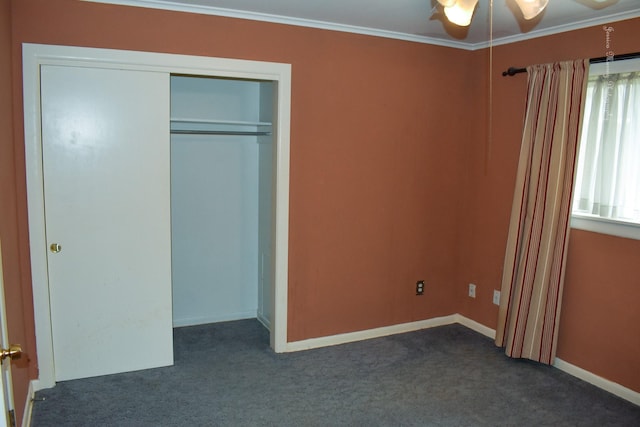 unfurnished bedroom with crown molding, a closet, ceiling fan, and dark colored carpet