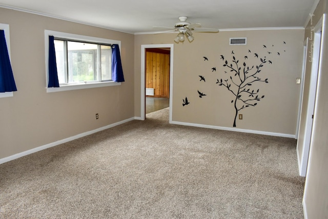 carpeted empty room featuring ceiling fan and crown molding