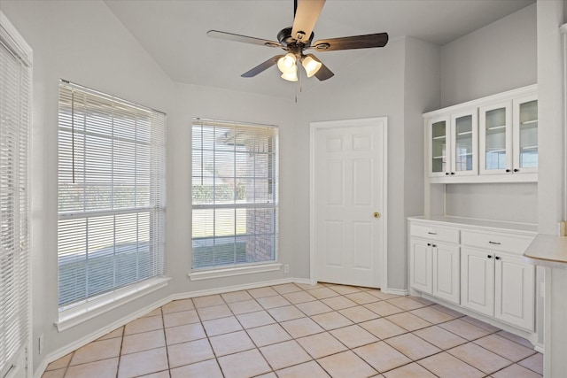 unfurnished dining area with light tile patterned floors and ceiling fan