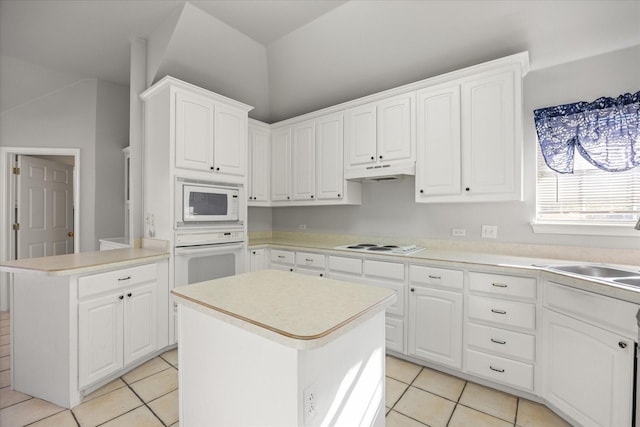 kitchen featuring sink, white appliances, white cabinetry, a kitchen island, and light tile patterned flooring