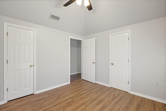 unfurnished bedroom featuring vaulted ceiling, hardwood / wood-style floors, and ceiling fan