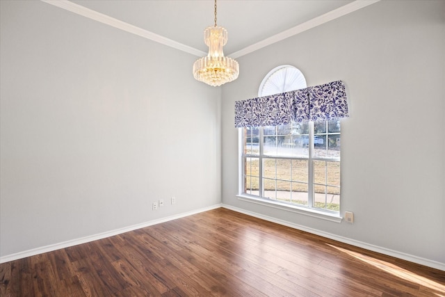 spare room with hardwood / wood-style flooring, crown molding, and a chandelier